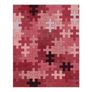 Getufter Puzzle-Teppich mit verschiedenen Schattierungen von roten, rosa und burgunderroten Puzzleteilen.