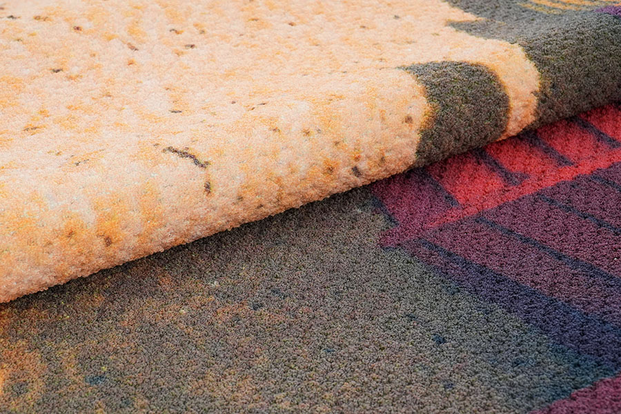 Detailansicht eines bedruckten Nylonteppichs mit einem Ozeanlandschaftsdesign, welches die Details seiner Schlingenfasern zeigt, mit verschiedenen Blautönen des Wassers, einer Horizontlinie und kleinen Inseln.