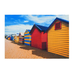 Ein individuell bedruckter Polyesterteppich mit einer Strandhüttenszene, die eine Reihe von bunten hölzernen Badekisten (rot, gelb, blau) am Sandstrand zeigt.
